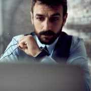 Email di phishing: attenzione ai messaggi in azienda Professionista con gli occhiali in mano che osserva attentamente lo schermo del computer