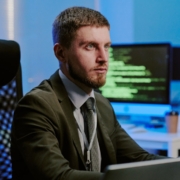 Firewall aziendale: monitoraggio e risposta Professionista al computer con più monitor alle spalle in un ambiente di lavoro IT